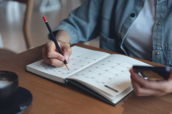 A woman marking dates on her calendar
