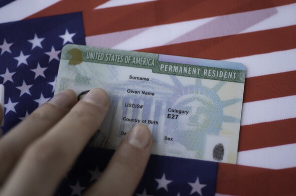  Permanent Resident Green card on a USA flag